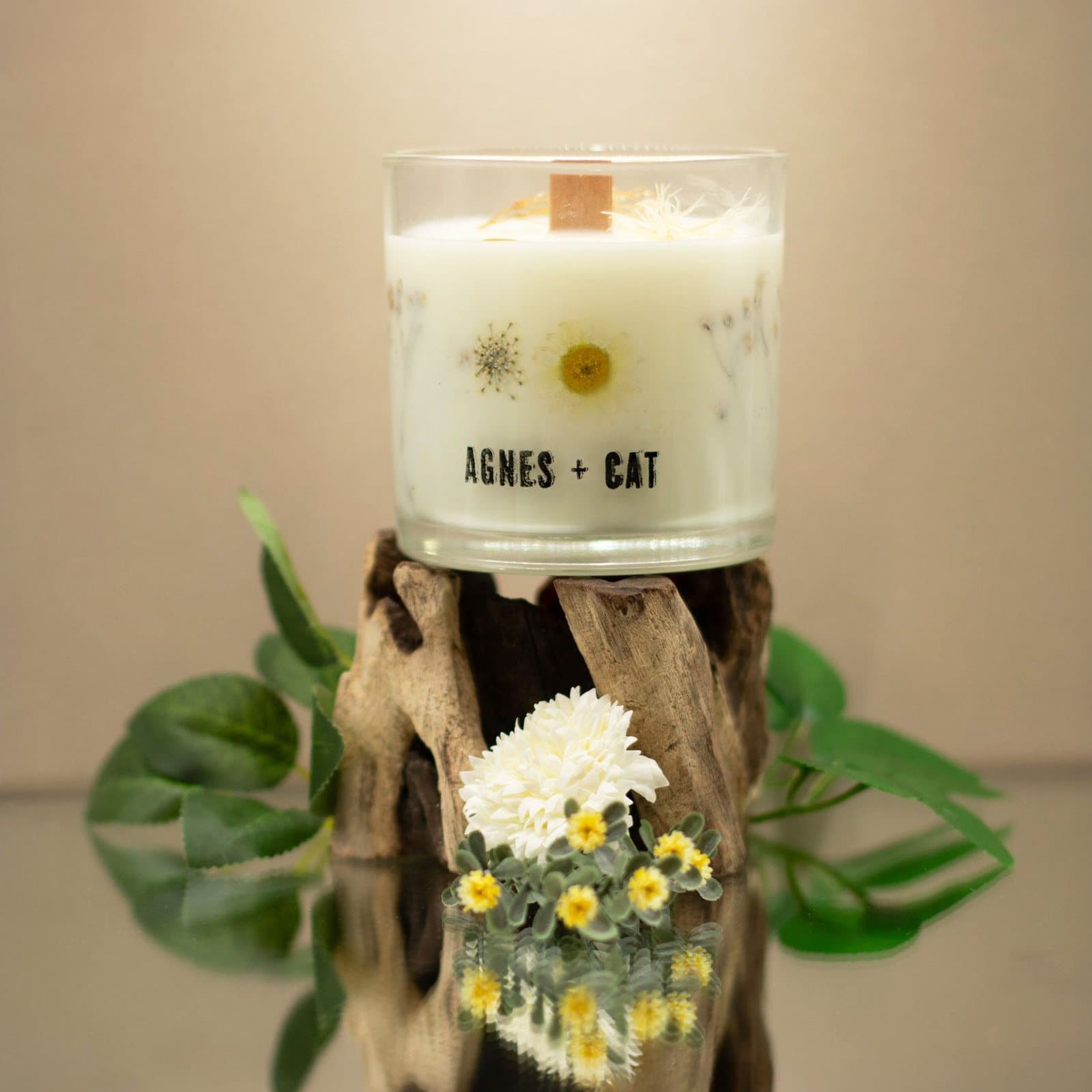 Botanical soy wax candle in a clear glass jar with dried florals in the wax