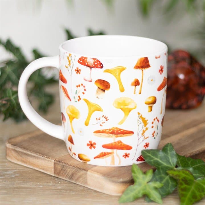 Cream mug with red and white speckled toadstools and floral accents