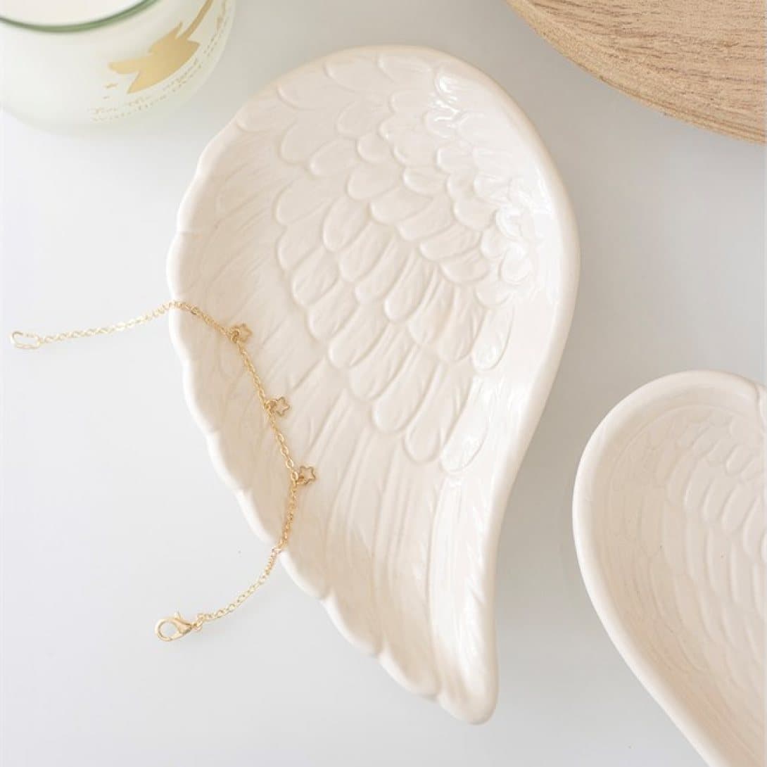 Off-white trinket dish shaped like an angel wing