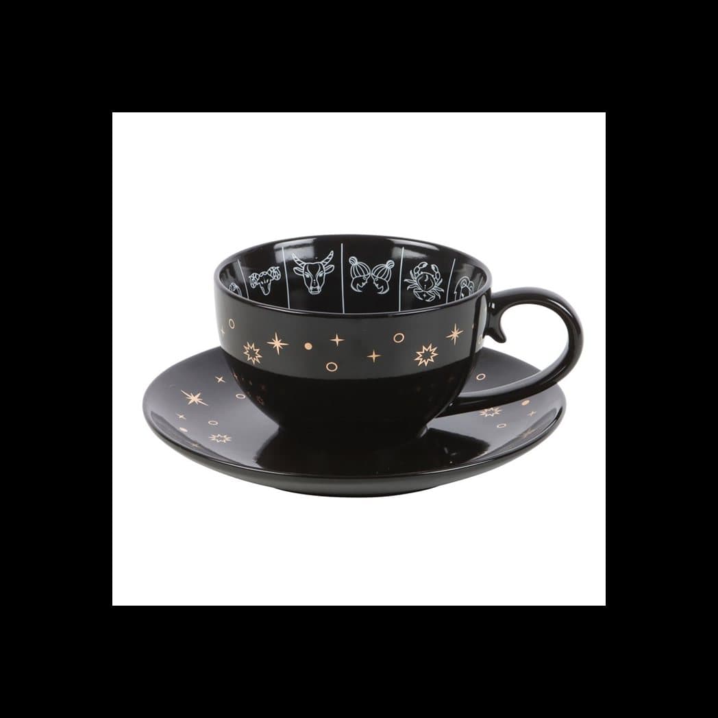 Black zodiac teacup and saucer with a white and gold astrology wheel