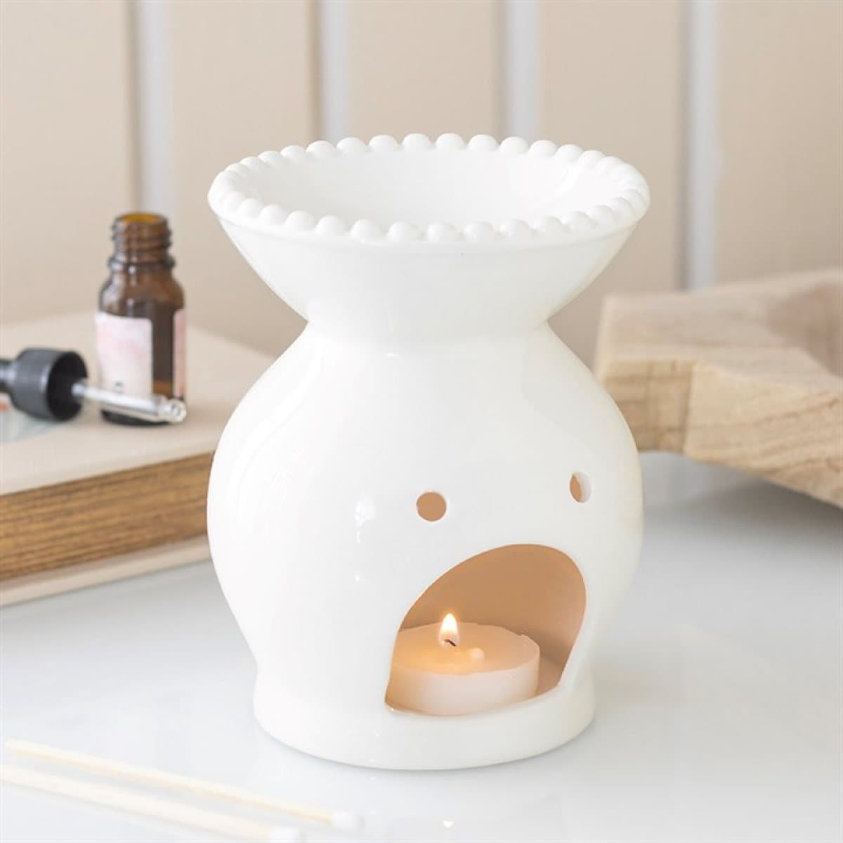 Ceramic oil burner with a decorative beaded rim