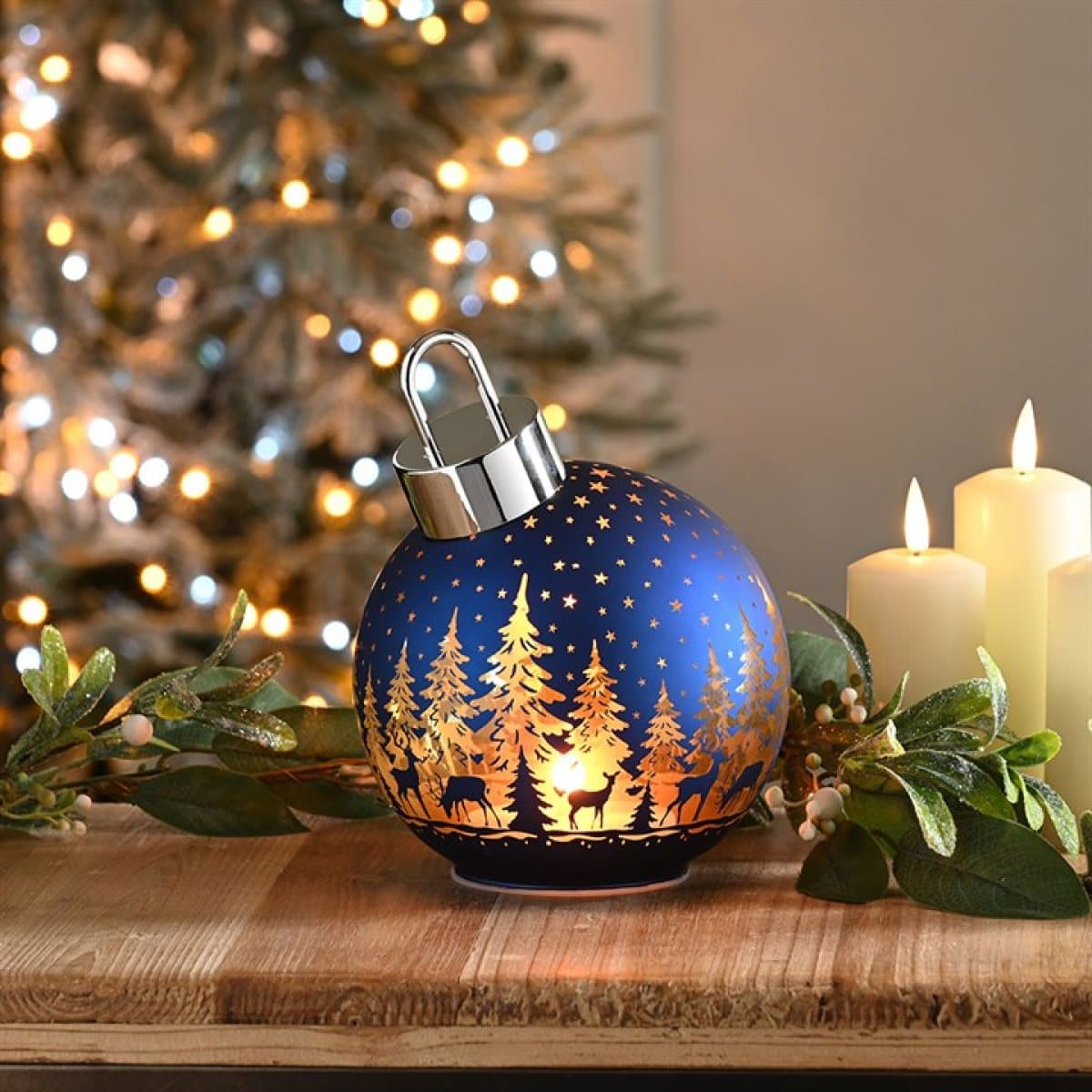 Blue glass bauble with a glowing reindeer and tree scene