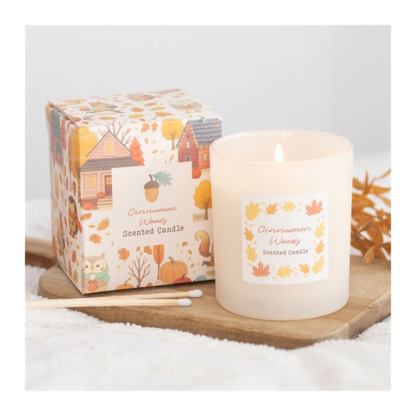 Cinnamon woods scented glass candle with its colour cardboard box