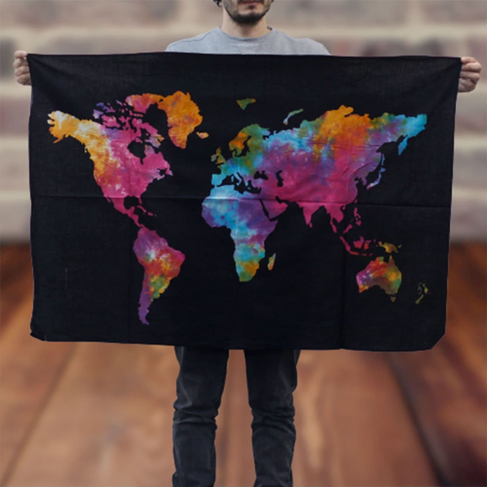 Cotton wall hanging showing a colourful world map on a deep black backdrop