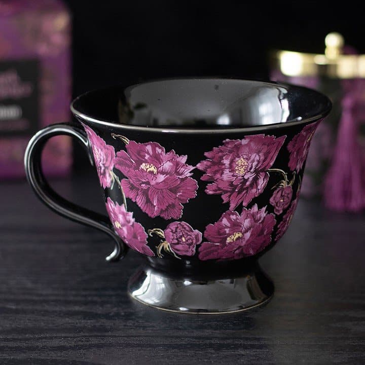 Black teacup with deep purple roses