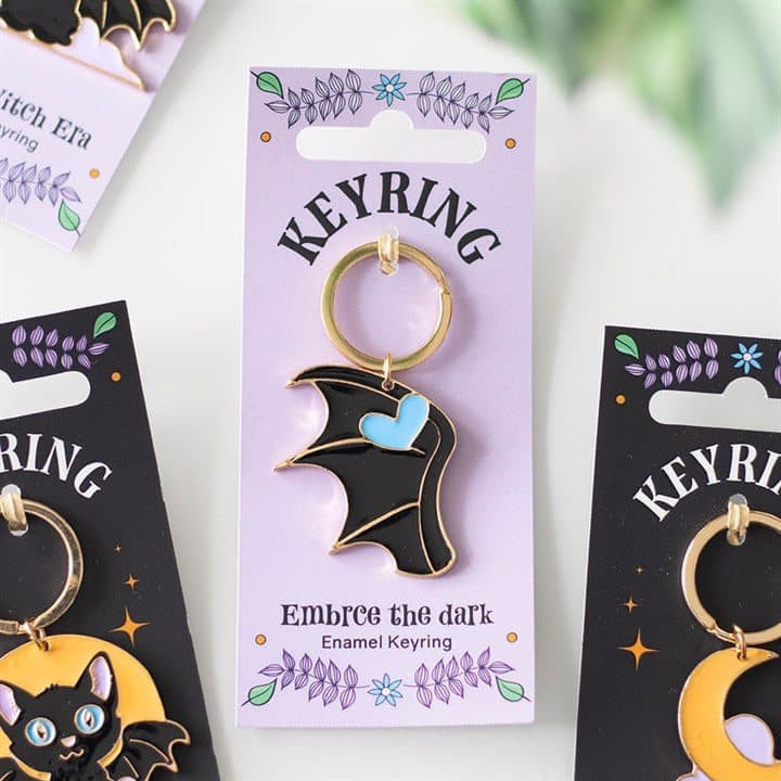 Embrace the Dark enamel keyring with a bat wing on a backing card