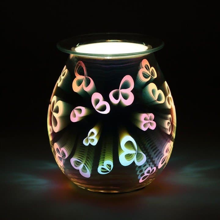 Glass electric oil burner lit up with colourful 3D flower petals