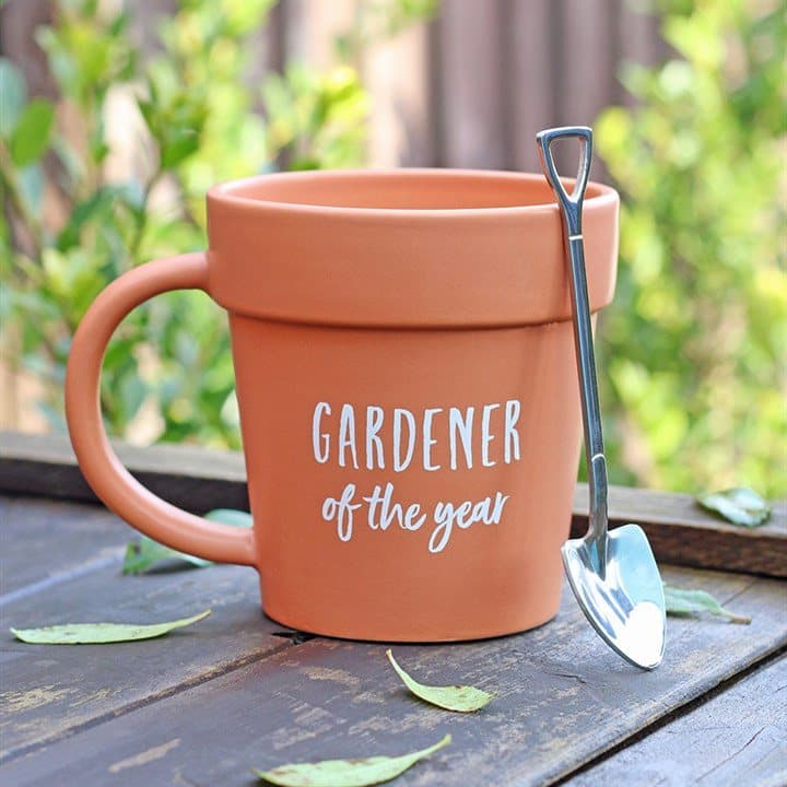 Terracotta-coloured ceramic plant pot mug with a shovel-shaped teaspoon