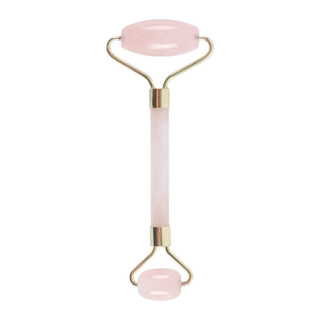 Rose quartz face roller with two polished rollers on a brass frame