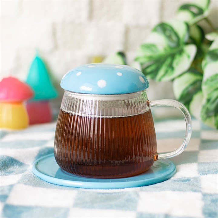 Sky blue glass mushroom mug sitting on a matching mushroom coaster