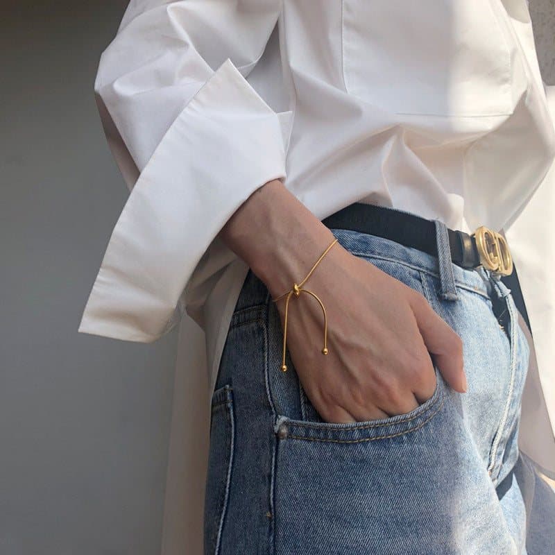 Gold simple slider bracelet on a plain background