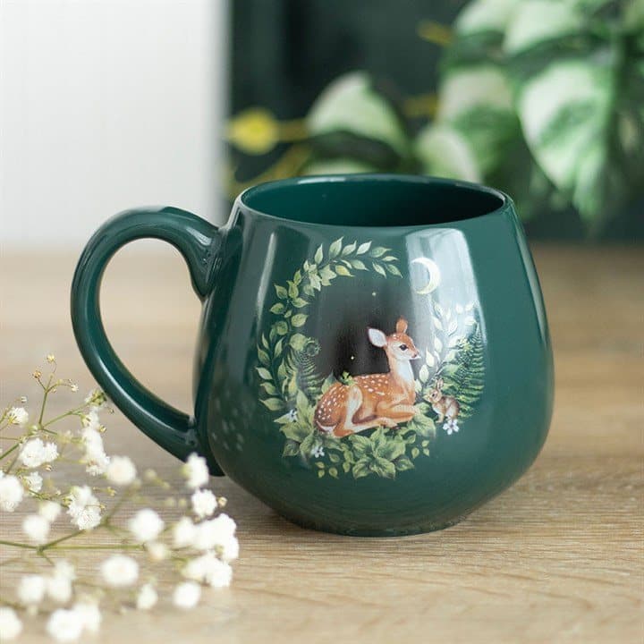 Green mug with a fawn and a bunny among leaves