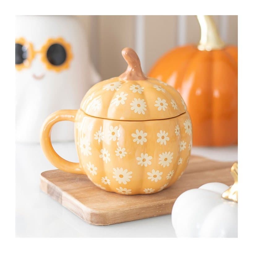Orange pumpkin-shaped ceramic mug with a groovy floral design and lid