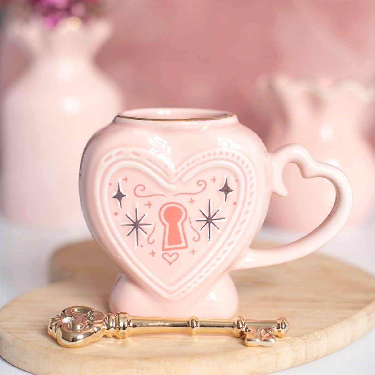 Pink ceramic heart locket mug with lock detailing and a gold-tone key stirrer