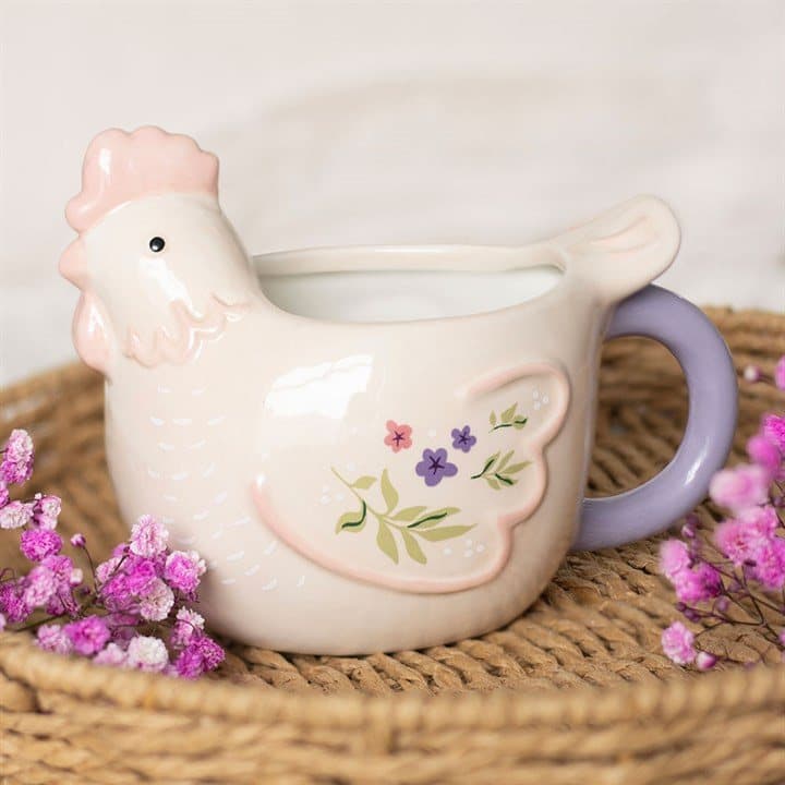 Hen shaped ceramic mug in soft pastels with floral accents and a lilac handle