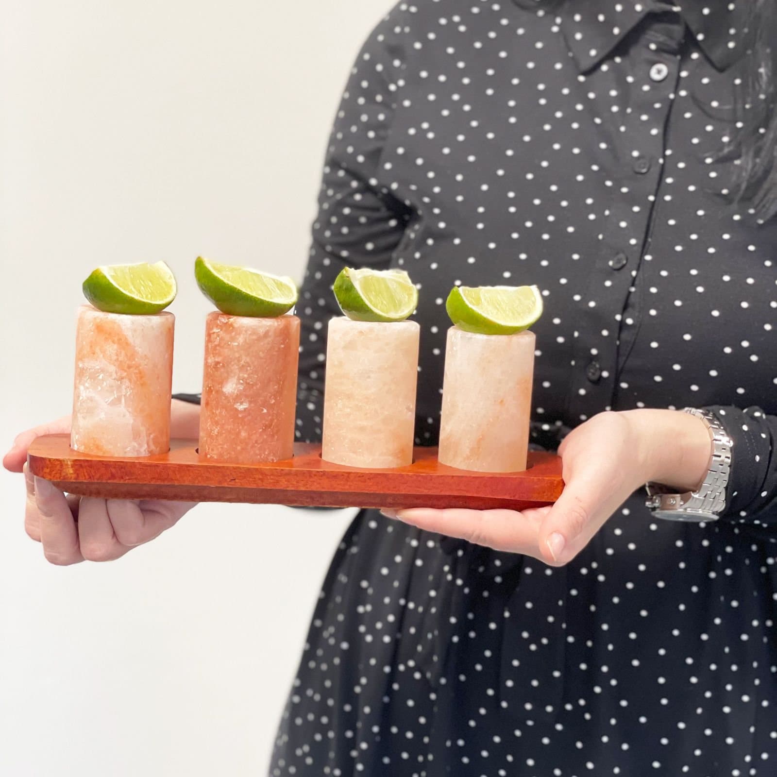 Himalayan salt shot glasses on a wood stand