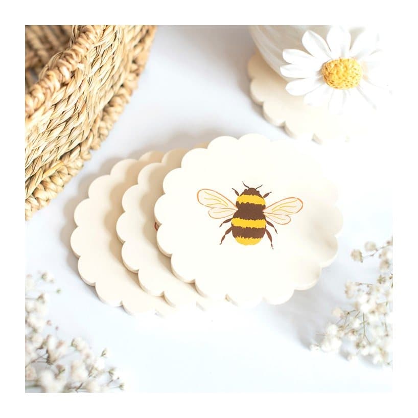 Four scalloped coasters with a honey bee design