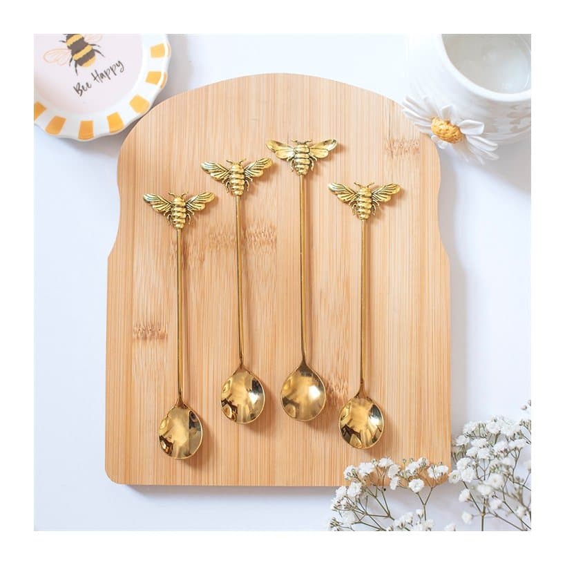 Four gold teaspoons with a honey bee detail