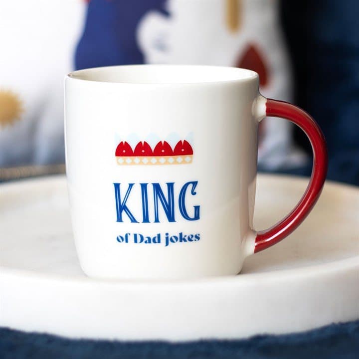 White ceramic mug with red handle and crown, King of Dad Jokes text