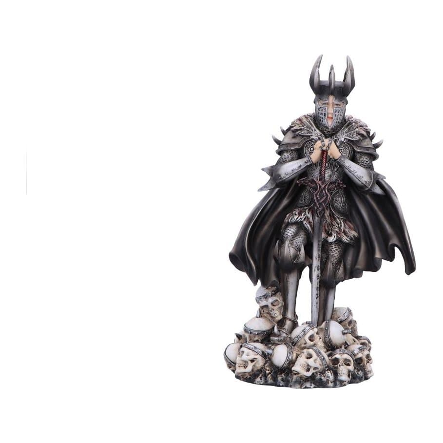 Gothic knight figurine in full armour, sword over a pile of skulls