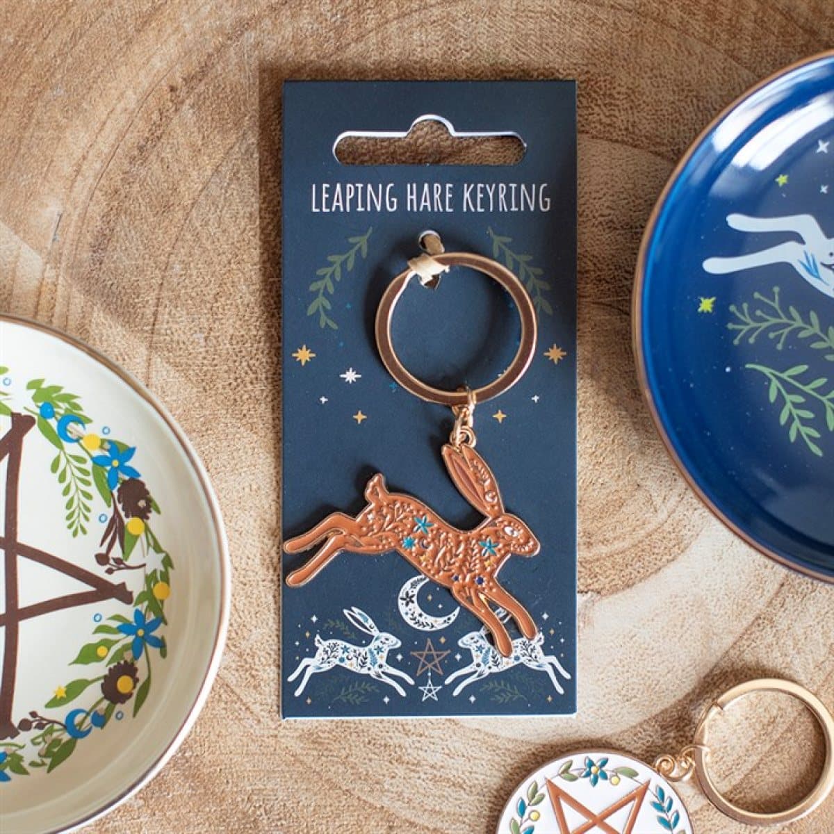 Keyring with a golden leaping hare and celestial moonlit artwork on a backing card