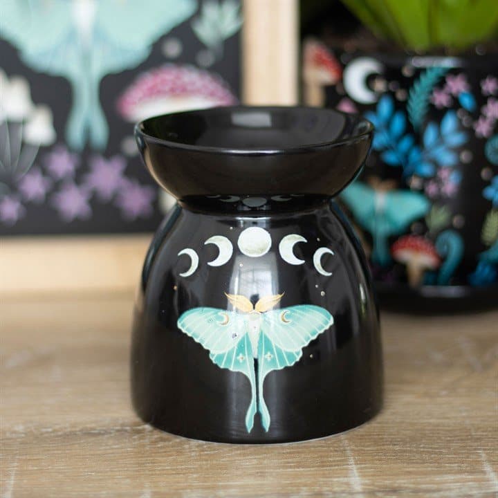 Black steel oil burner with a luna moth and silvery moon phases design