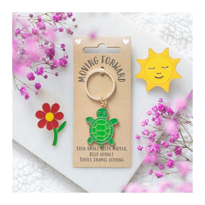 Green turtle keyring with a friendly face on a cardboard back
