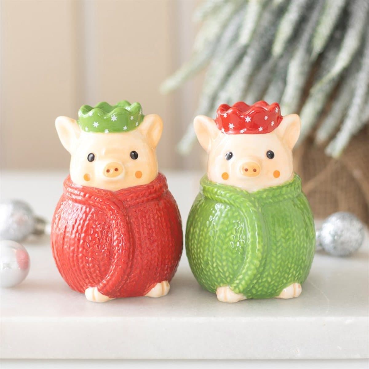 Two ceramic pig salt and pepper shakers in red and green knitted blankets