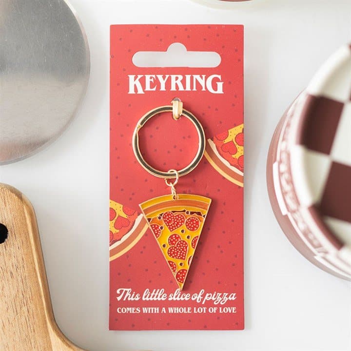 Enamel pizza slice keyring with heart-shaped pepperoni on a backing card