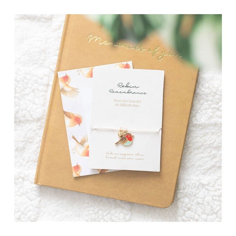 String bracelet with a robin charm and tiny golden heart on a sentiment card
