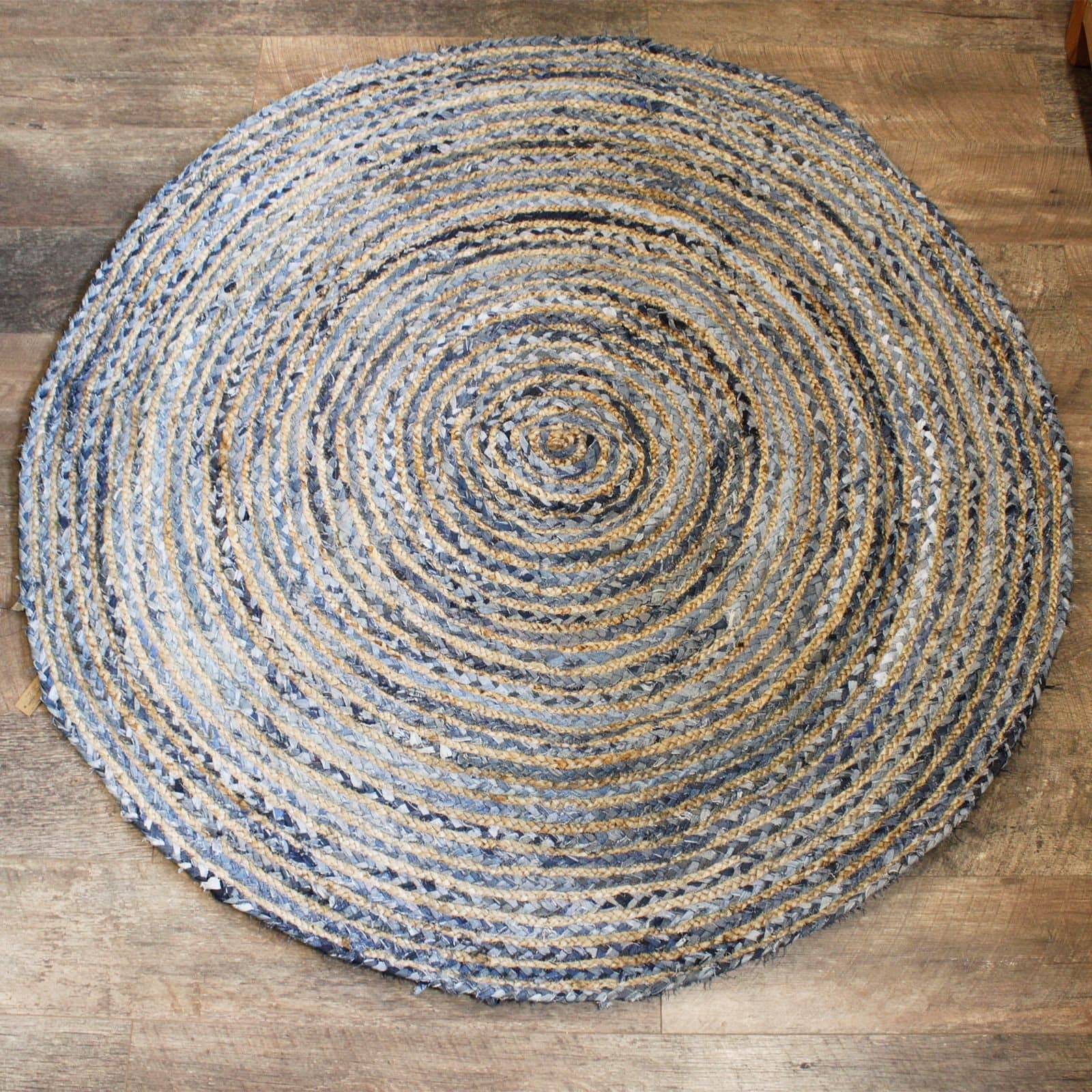 Round jute and recycled denim rug laid out in a living area