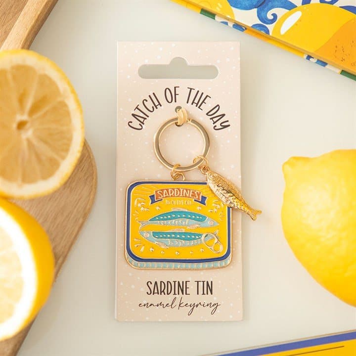 Enamel keyring shaped like a classic sardine tin on a cardboard back