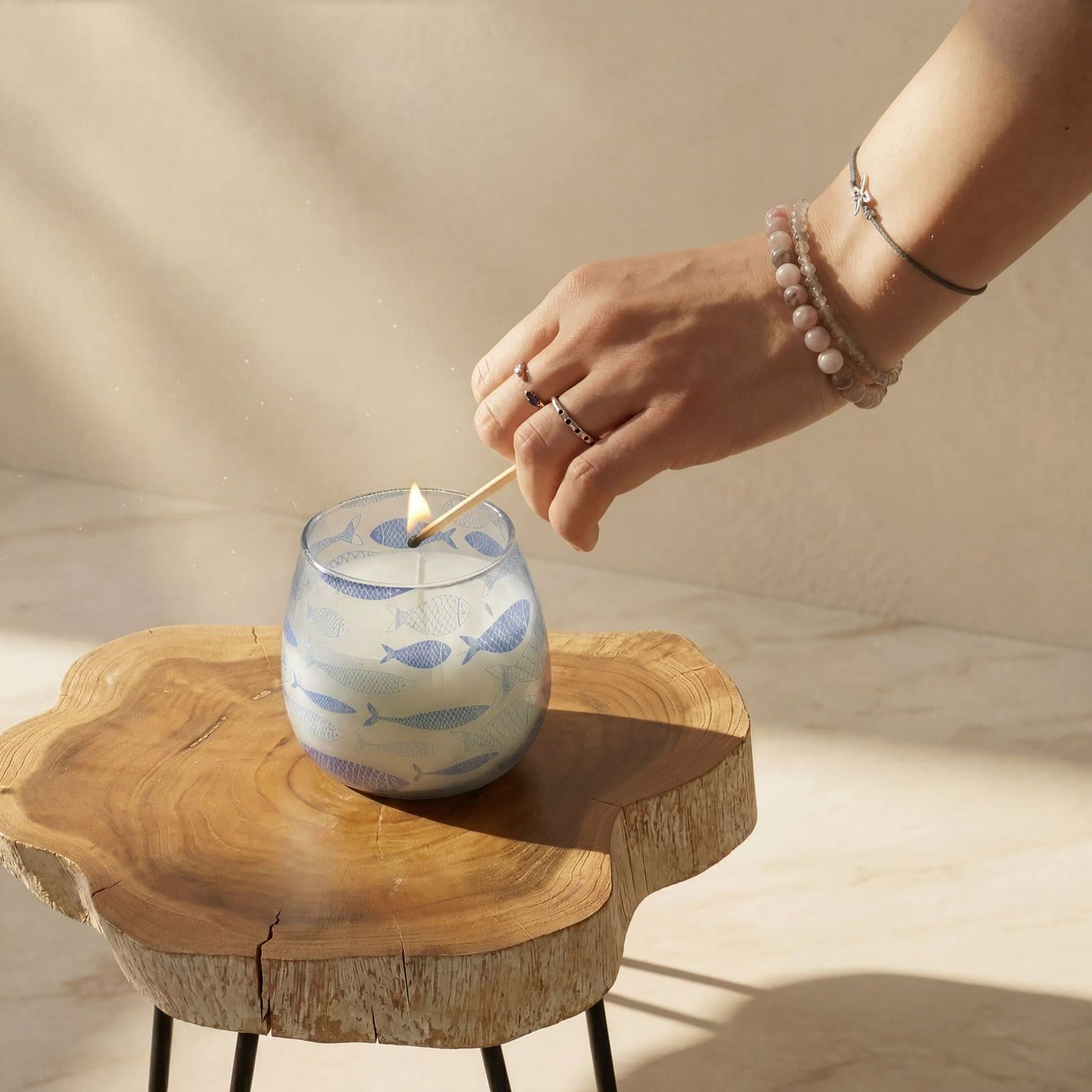 Clear glass candle with a blue fish pattern