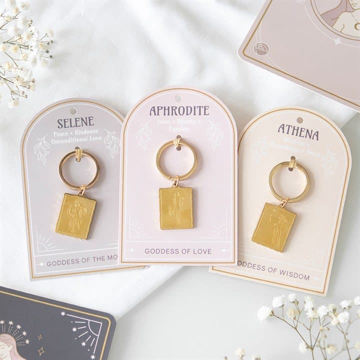 Set of goddess energy keyrings with gold-toned pendants on backing cards