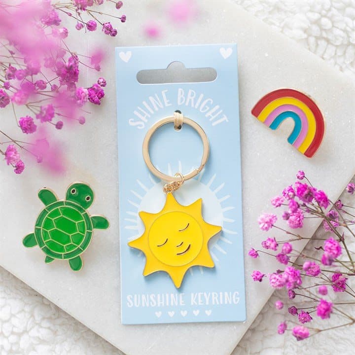 Bold yellow enamel sun keyring on a cardboard back