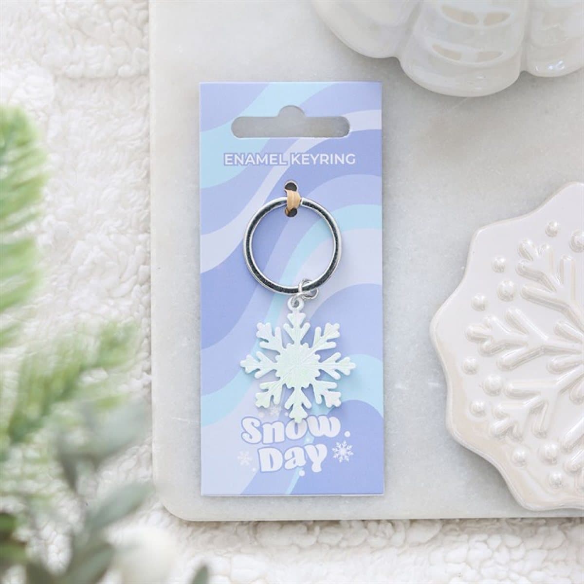 Snow Day snowflake keyring on a cardboard back