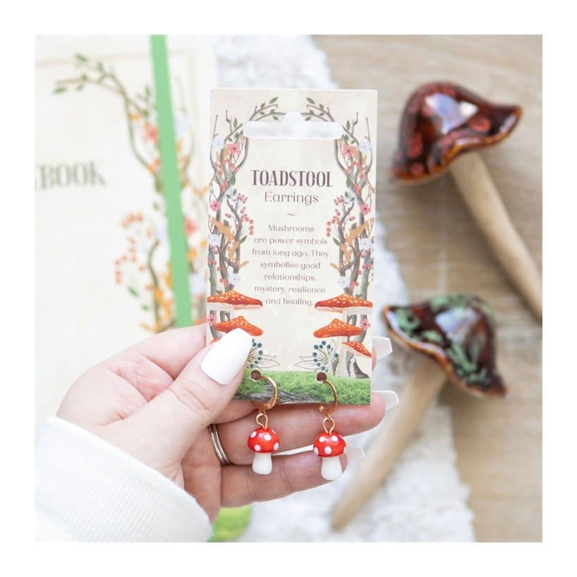 Toadstool mushroom earrings hanging from small gold hoops