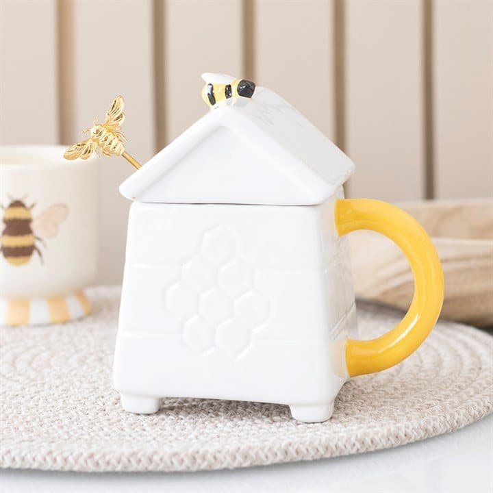 White ceramic beehive-shaped mug with a gold-effect bee spoon