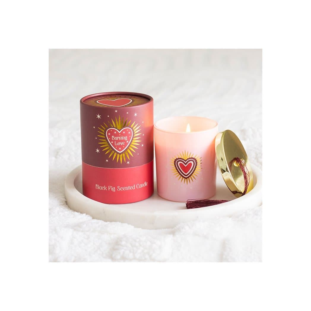 Blush pink glass candle jar with gold lid and tassel, with a sacred heart design