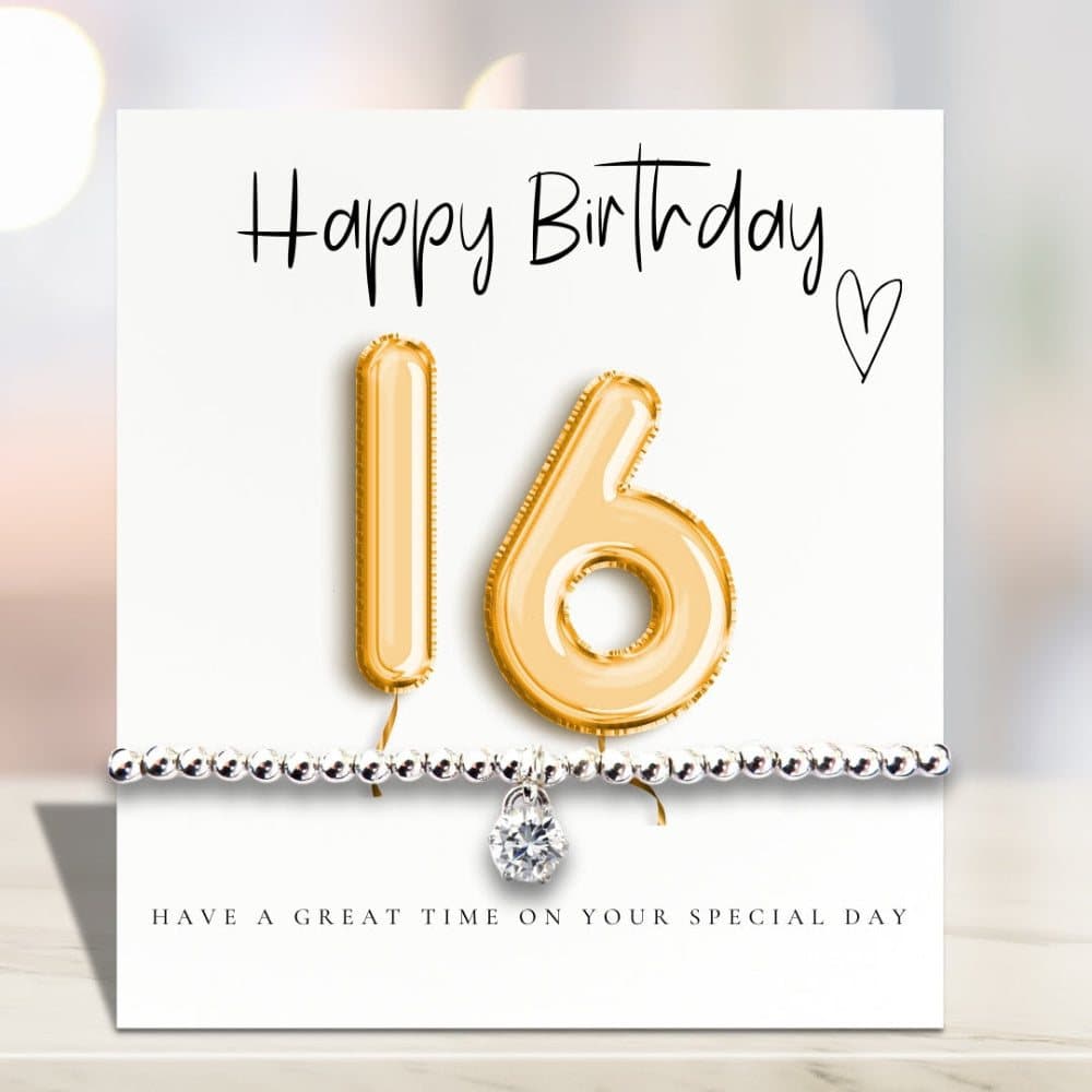 Silver stretch bracelet with a cubic zirconia charm beside a gold balloons birthday card