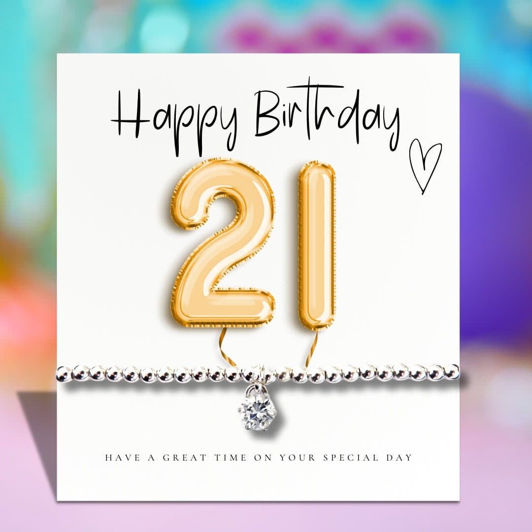 Silver stretch bracelet with cubic zirconia charm beside a gold balloons card