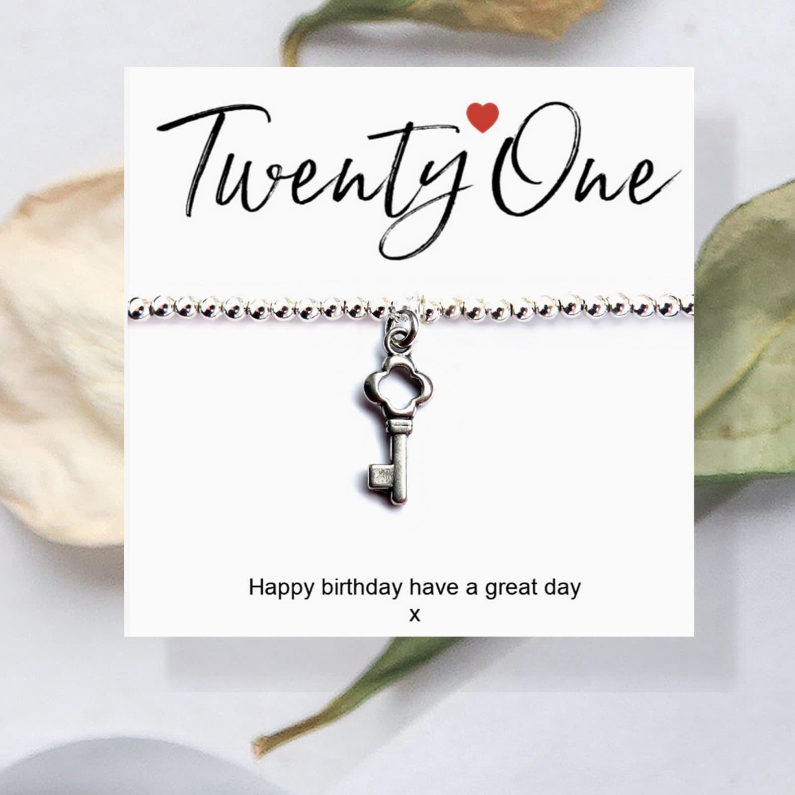 Silver beaded stretch bracelet with a key charm and a 21st birthday card
