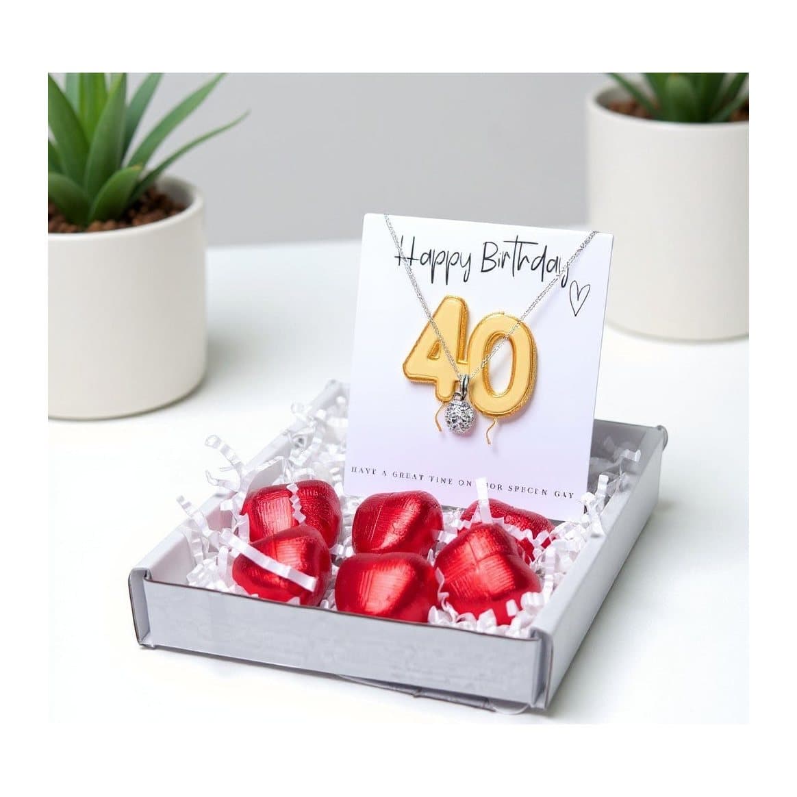 40th birthday gift box with a silver necklace, gold balloons and chocolate hearts