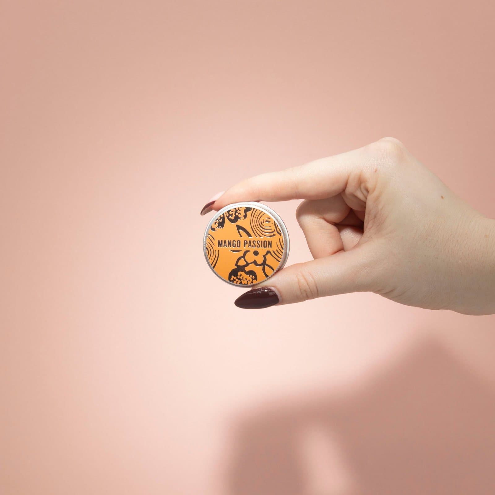 Mango passion fruit lip balm in a small aluminium tin with an illustrated design