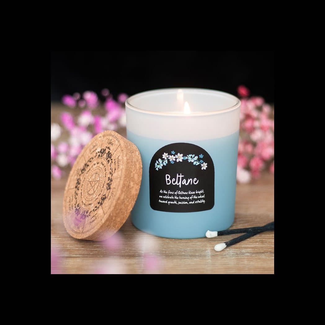 Beltane orange blossom candle in a glass jar with a cork lid