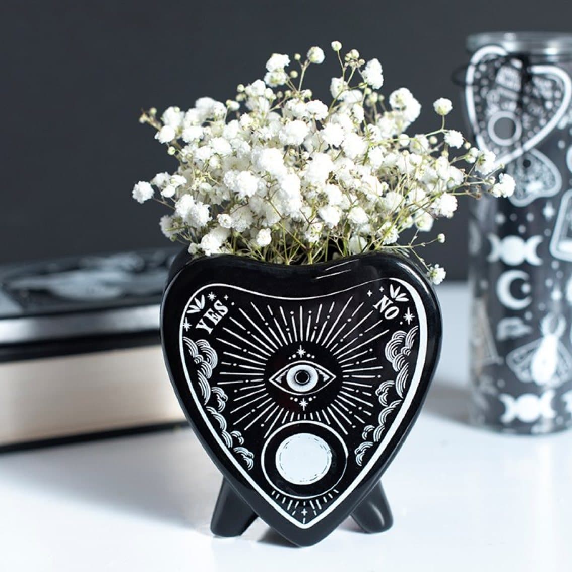 Black ceramic flower vase shaped like a planchette
