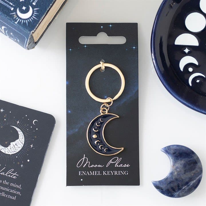 Gold-tone enamel crescent moon phase keyring on a cardboard back