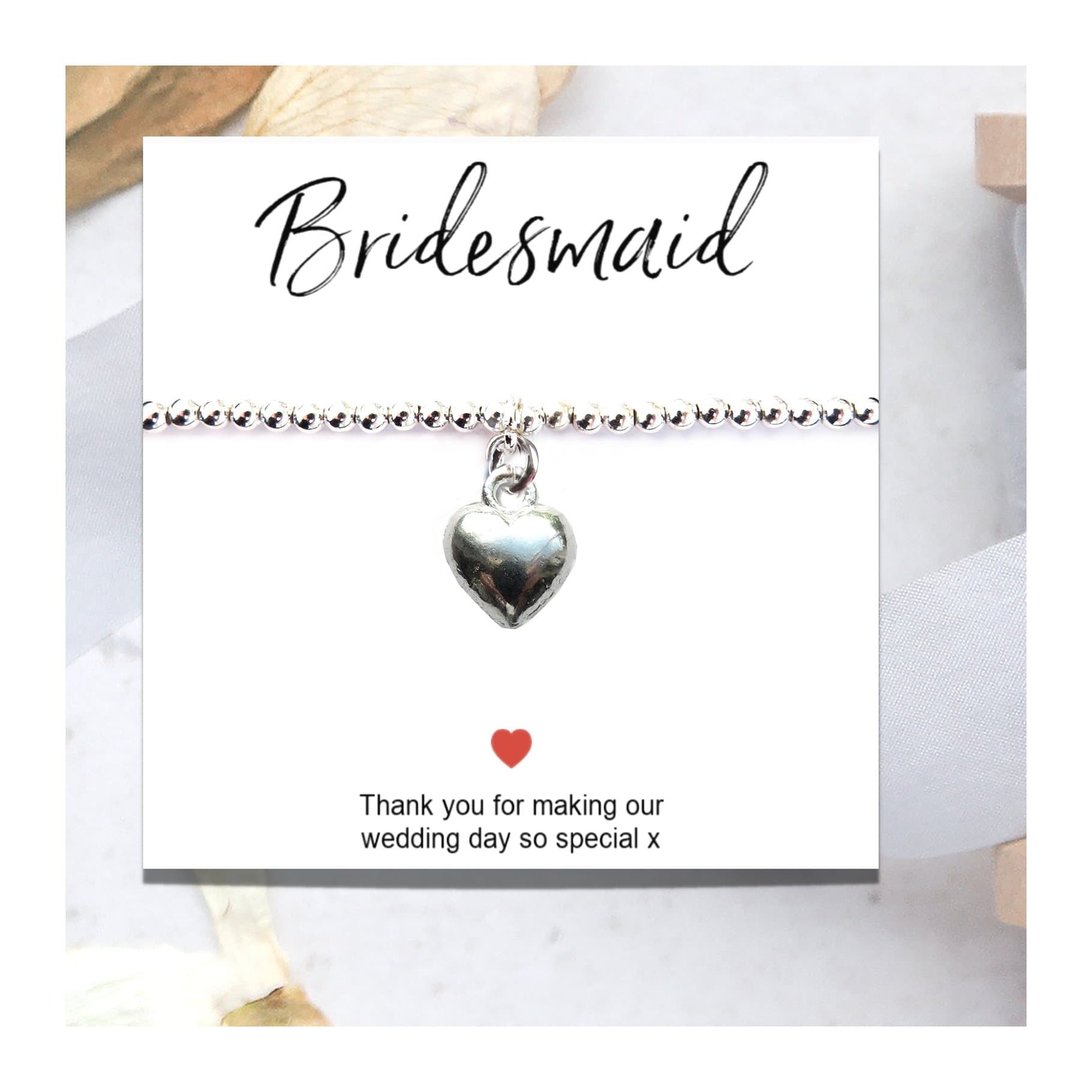 Silver heart charm stretch bracelet on a thank you gift card for bridesmaids.