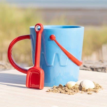 Blue ceramic bucket-shaped mug with a red spade-shaped spoon