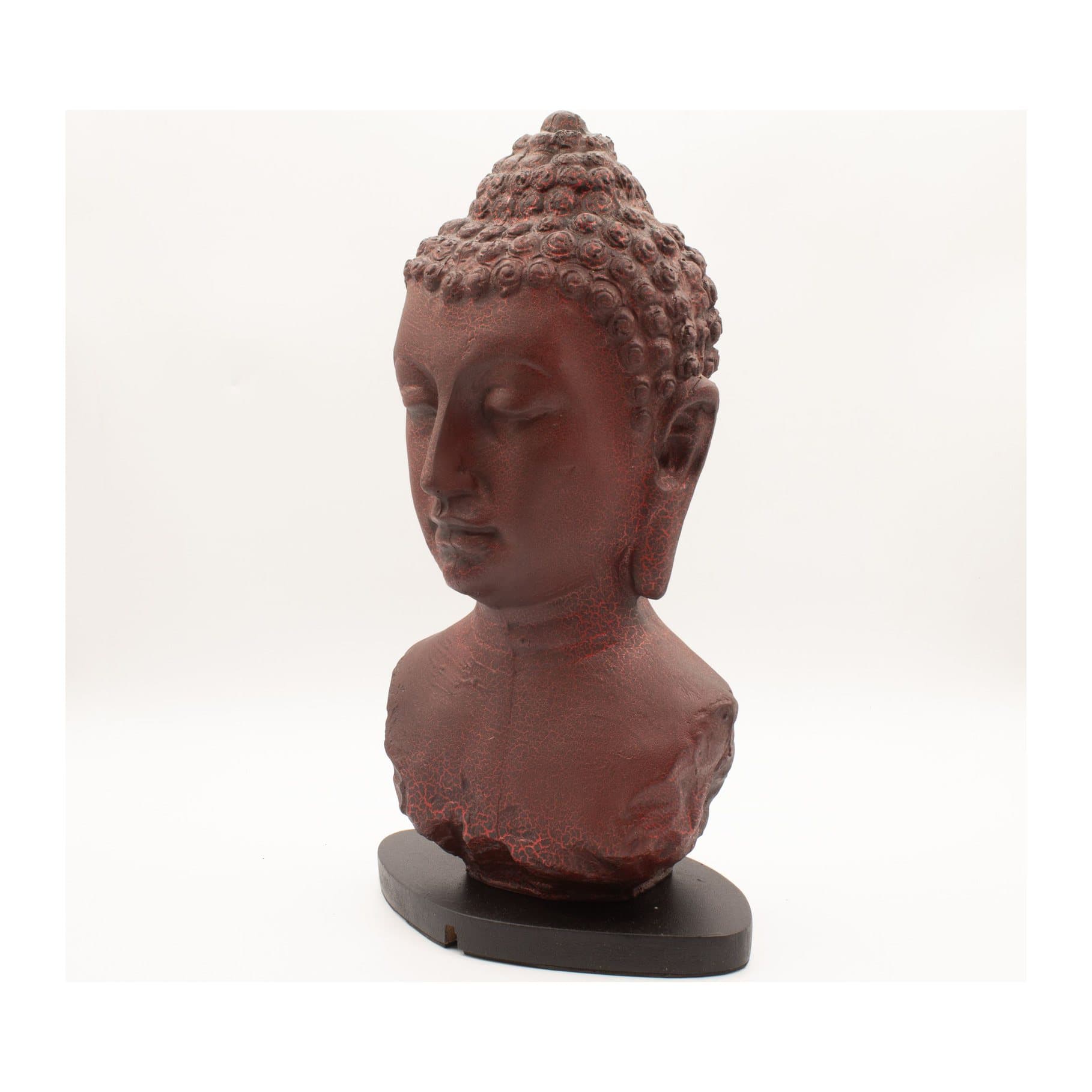 Buddha bust lamp in molten lava finish glowing red on an oval base